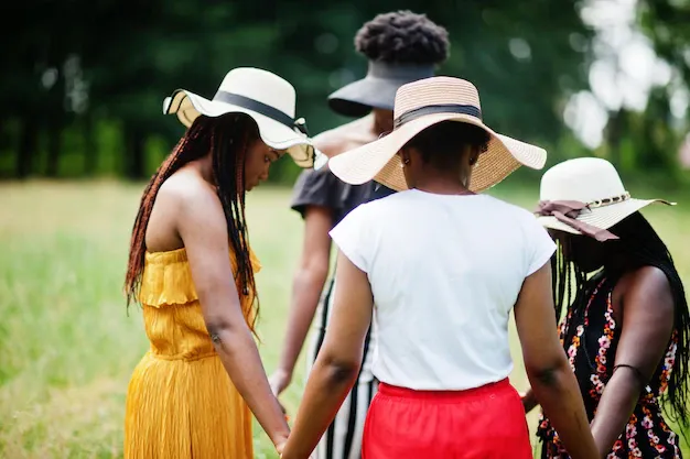 group-four-gorgeous-african-american-womans-wear-summer-hat-holding-hands-praying-green-grass-park_627829-4252.webp