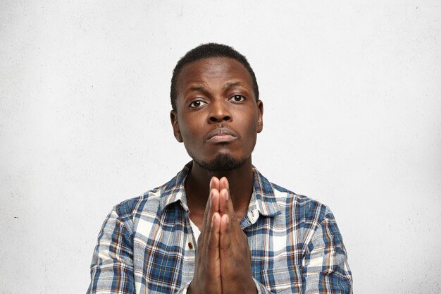 praying-young-afro-american-male-pressing-hands-together-having-guilty-look_273609-9555.jpg