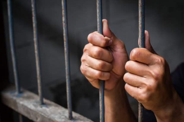 Canva-Hands-of-man-behind-jail-bars.-620x413.jpg