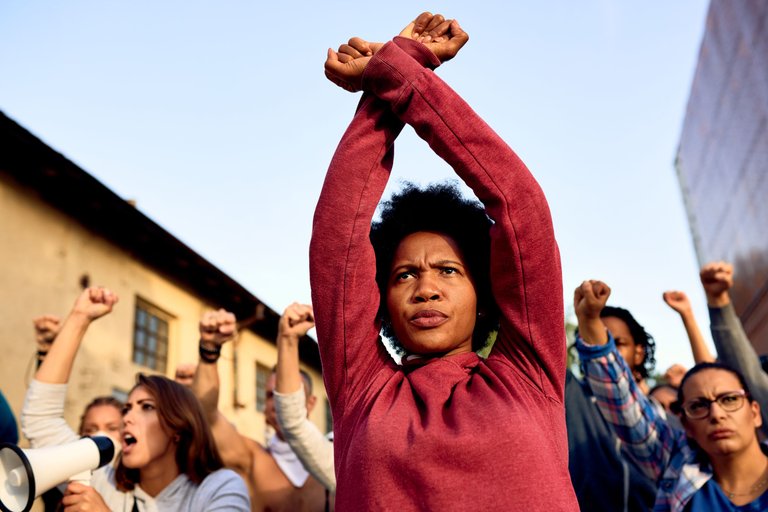 low-angle-view-african-american-woman-with-armcrossing-gesture-participating-protest-human-rights.jpg