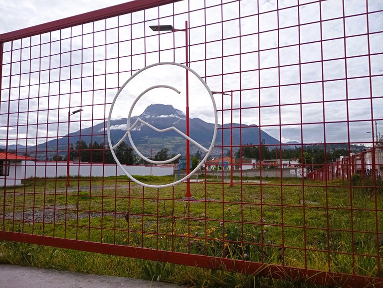 This is actually a low fence in comparison to others. The logo is of Cotacachi, but ironically the mountain in the picture is the Imbabura. The white part crossing the C is the shape of Mountain Cotacachi.