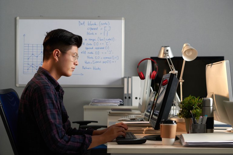 side-shot-young-asian-man-glasses-working-computer-office.jpg
