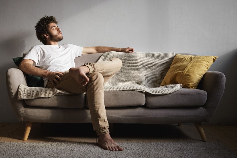 picture-stylish-handsome-young-guy-with-fuzzy-beard-voluminous-hairdo-bare-feet-keeping-eyes-closed-falling-asleep-listening-classical-music-enjoying-leisure-time-sitting-couch.jpg