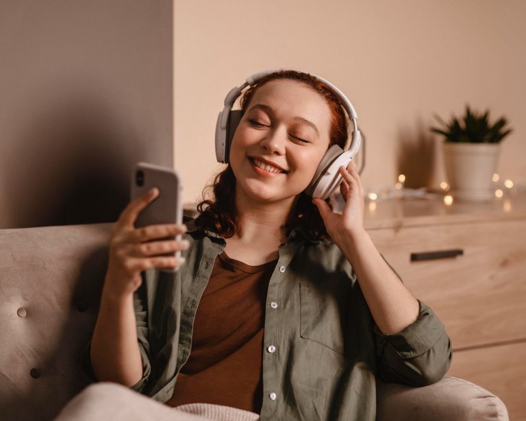 woman-using-modern-headphones-smartphone-home.jpg