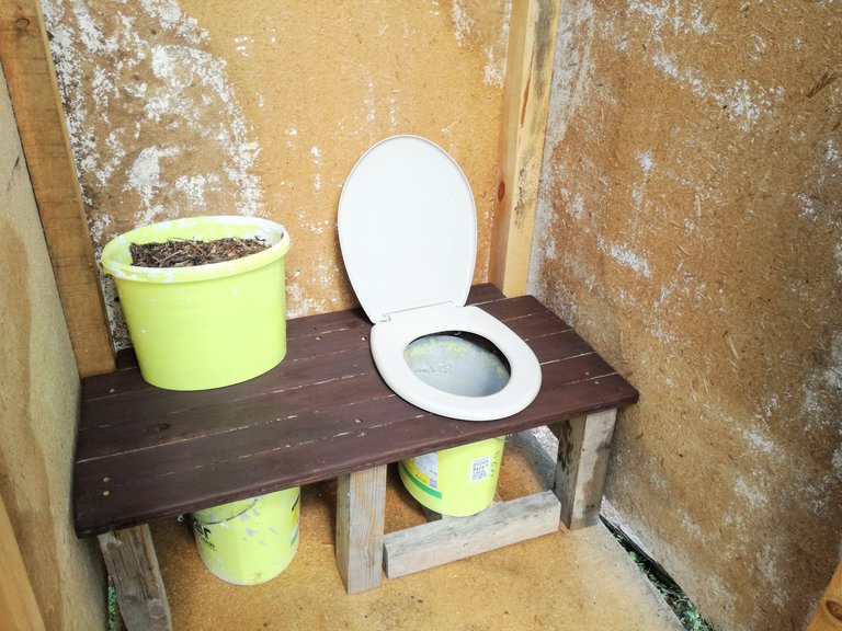 Outdoor compost toilet made almost entirely out of trash.