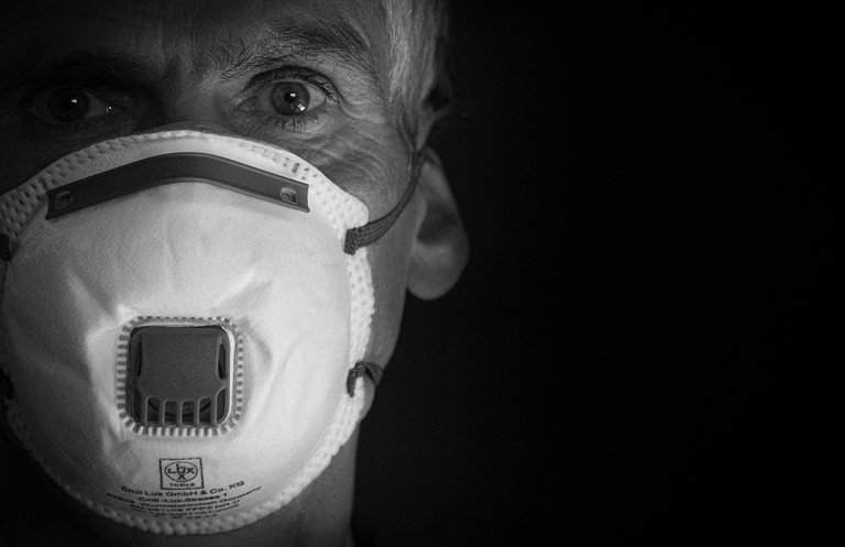 A photograph of a man wearing a mask