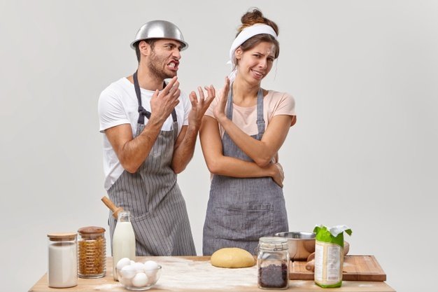 ama-casa-molesta-no-quiere-escuchar-al-marido-molesto-cocinar-cena-juntos-permanecer-irritada-cansada-usar-productos-saludables-hacer-masa-aislado-pared-blanca-culinaria-comida-gente_273609-37852.jpg