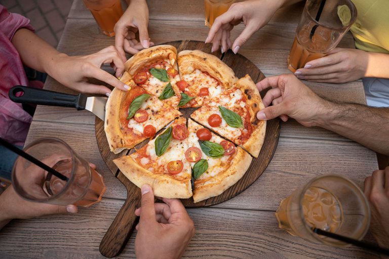 close-up-hands-holding-pizza-slices.jpeg