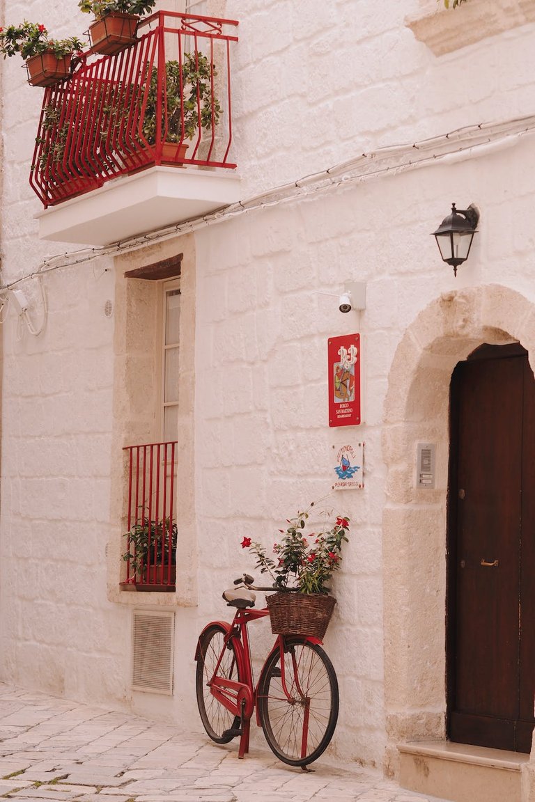 free-photo-of-red-bike-with-flowers-in-basket-leaning-against-wall.jpeg