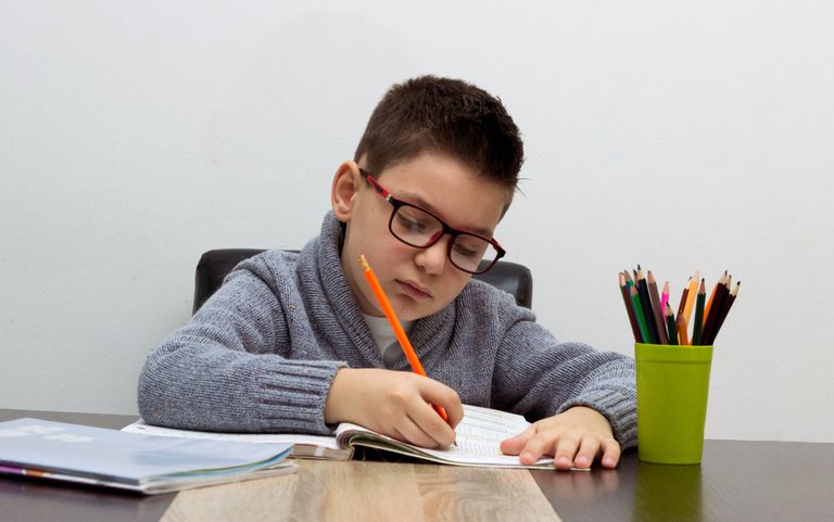 nino-siete-anos-escribiendo-casa-muchacho-que-estudia-tabla-nino-dibujo-lapiz.jpg