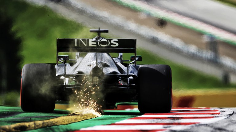 SparksflyasLewisHamiltondrivesoverayellowkerbaheadofthe2020F1AustrianGrandPrix.jpg