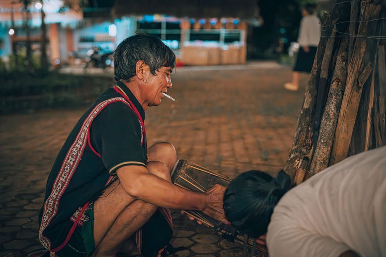 The old man heats the drum to relax it before performing