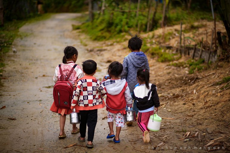 These kids are on their way to school. They carry the ketchup for lunch. The school is right in the village and their parents don't come back from work until late in the afternoon, so they bring their lunch and stay at the school all day.