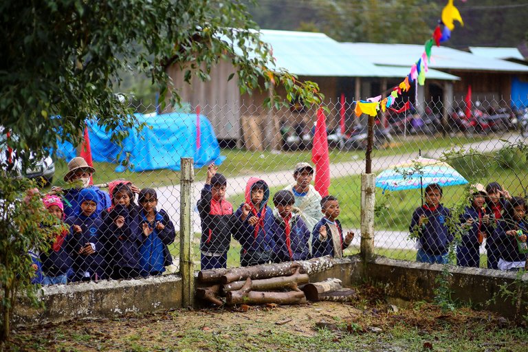 Many local people watched the performances in the fair from outside through a fence.