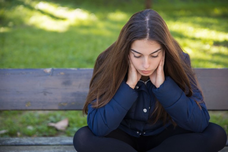 pensive-pretty-woman-sitting-on-bench-in-park.jpeg