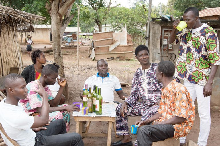 villagers-drinking-palm-wine-anekro-ivory-coast-august-gathered-under-tree-sitting-around-table-78479693.jpg