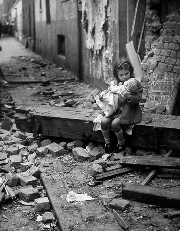 17-Little-girl-with-her-doll-sitting-in-the-ruins-of-her-bombed-home-London-1940.jpg