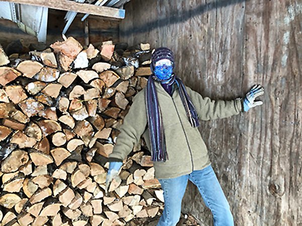 Becky Jones stacks wood in the wood shed Feb. 2021.jpg