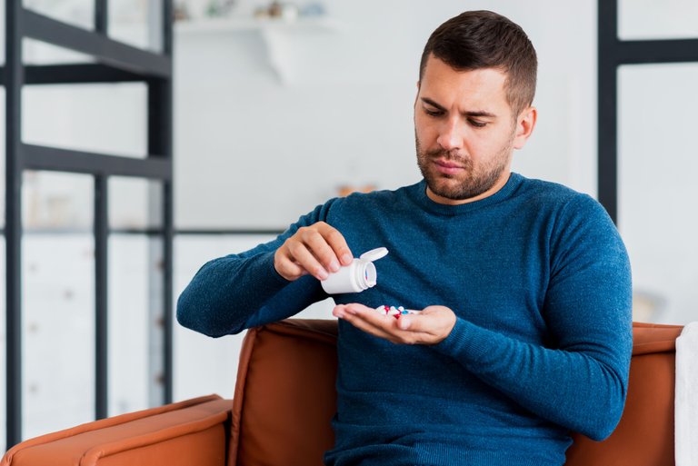 man-home-sitting-couch-taking-pills.jpg