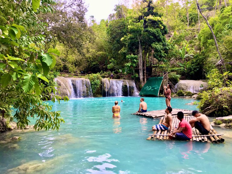 Local and foreign tourists chilling in the natural pools of Cambugahay Falls