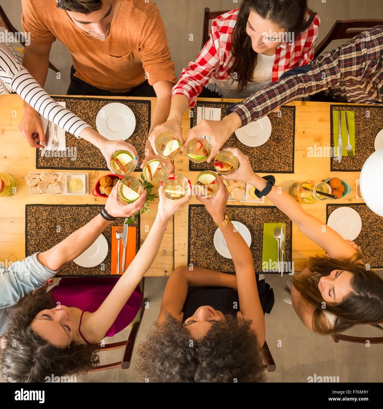 group-of-people-toasting-and-looking-happy-at-a-restaurant-F76M9Y.jpg