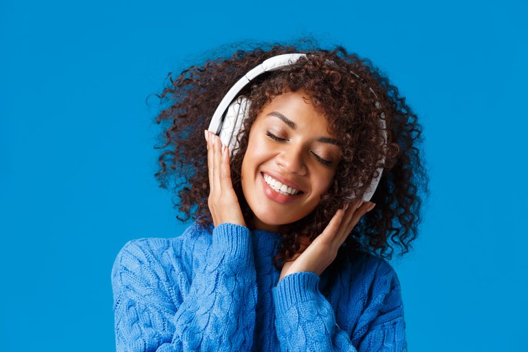 close-up-portrait-happy-smiling-romantic-tender-african-american-woman-enjoying-listening-music-headphones-tilt-head-close-eyes-dreamy-grinning-delighted-blue-wall.jpg