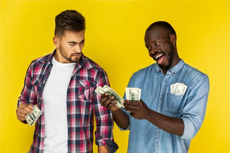 playful-african-man-joking-with-beautiful-european-man-while-holding-money.jpg