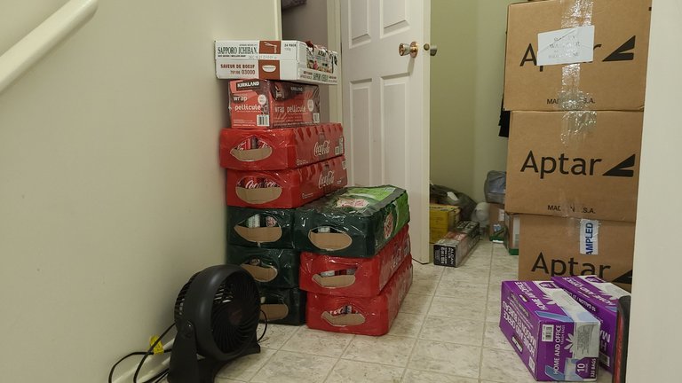 8 flats of coke and ginger ale, ramen, and various other goods chucked on the floor. Boxes are filled with various dry goods and SodaStream refills