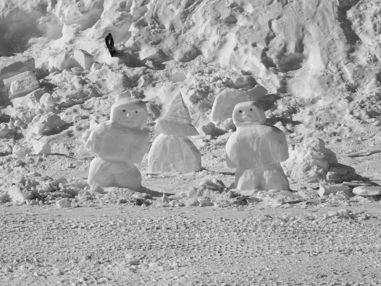 A tiny set of inukshuks. Notice the saw handle in the background. That is how they carve out chunks of hardened snow.