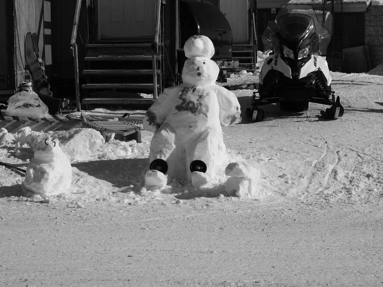 A silly snowman lounging lazily. His chest is colored purple.