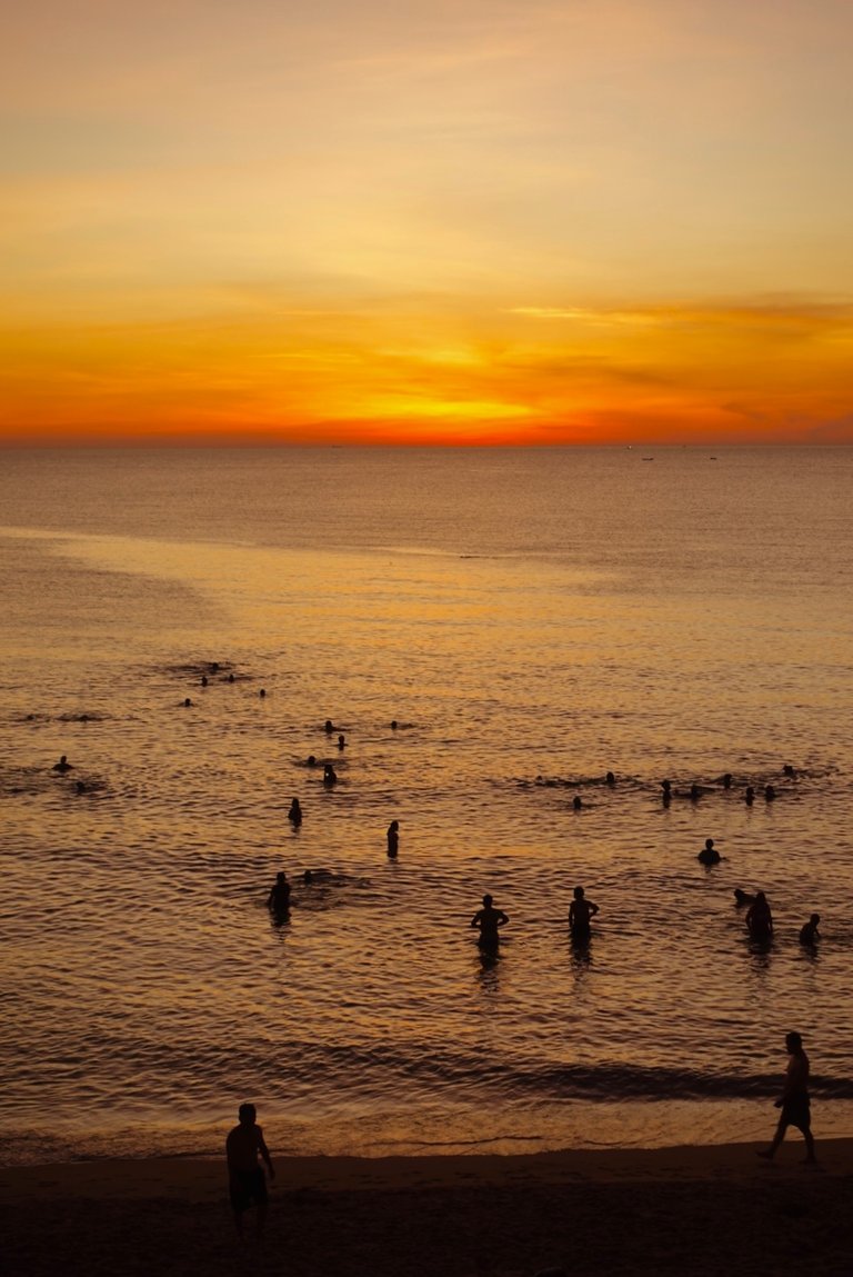 Many people swim in the sea early in the morning.