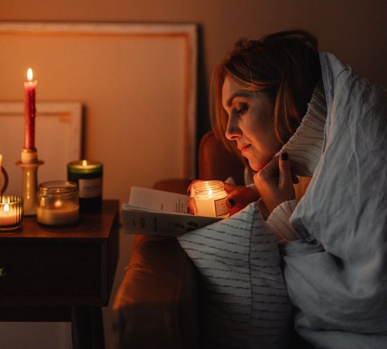 kaboompics_A woman holds a burning candle in her hands - reading a book.jpg