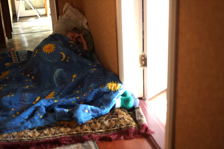 My mother, who is resting in the hallway during an air raid in Kyiv