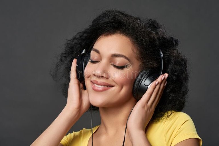 mujer-escuchando-música-con-los-ojos-cerrados-clausura-de-una-joven-raza-mixta-africana-en-auriculares-retrato-estudio-169271375.jpg