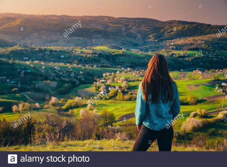 mujer-mirando-la-naturaleza-de-la-manana-de-primavera-luz-calida-del-amanecer-y-arboles-de-flores-en-el-fondo-edite-el-espacio-para-su-presupuesto-o-montaje-2bk337a.jpg