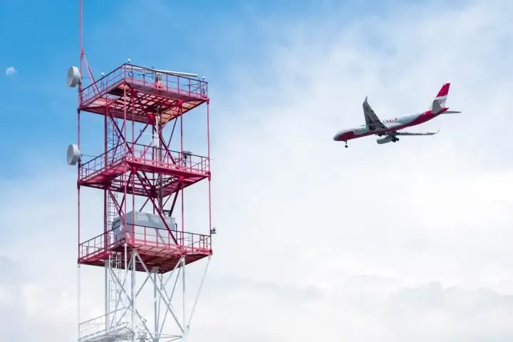 aircraft-flying-past-radio-communications-tower.webp