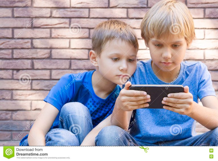 niños-con-el-teléfono-móvil-dos-muchachos-que-miran-la-pantalla-jugando-juegos-o-usando-el-uso-outdoor-tecnología-77464933.jpg