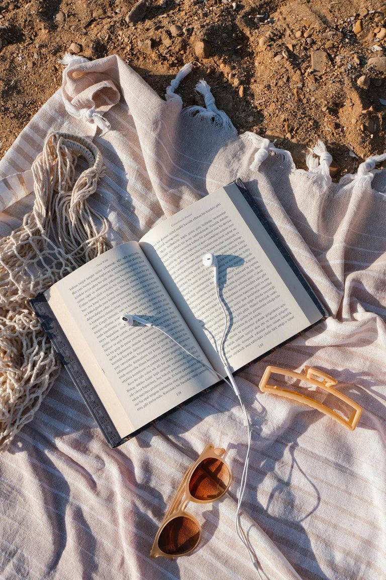 free-photo-of-book-headphones-bag-and-sunglasses-on-blanket-on-sand.jpeg