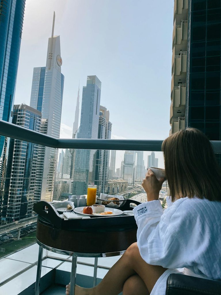 free-photo-of-woman-eating-on-balcony-in-modern-city-downtown.jpeg