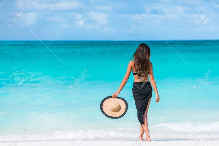 56700647-mujer-en-bikini-negro-sarong-y-de-pie-en-la-playa-elegante-hembra-atractiva-está-usando-bikini-negro-y (1).jpg