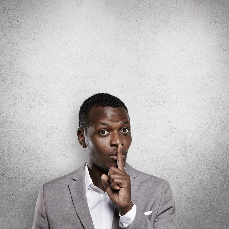 handsome-dark-skinned-young-businessman-formal-gray-suit-gesturing-as-if-asking-tell-anyone-about-his-commercial-secret-holding-his-index-finger-his-lips-saying-shh_273609-5837.jpg