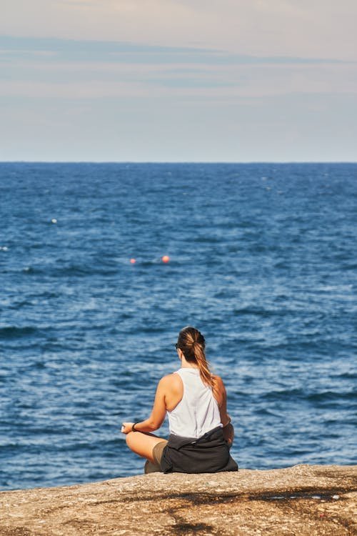 free-photo-of-a-woman-meditating-on-a-rock-by-the-ocean.jpeg