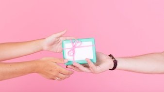 man-s-hand-giving-gift-her-woman-against-pink-background_23-2147890954.jpg