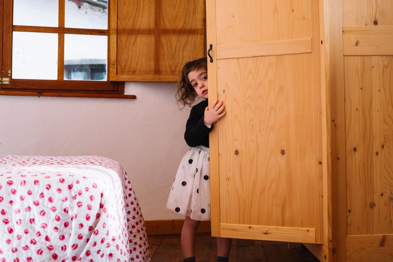 cute-girl-peeking-from-wooden-cupboard.jpg