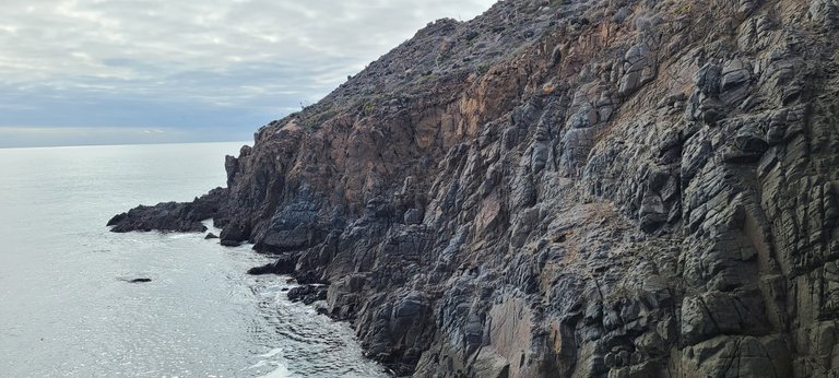 A view of the rocky cliffs along the edge of the water near the blow hole