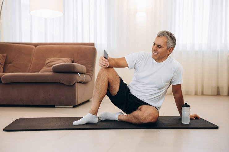 senior-man-resting-after-home-workout-with-water-phone_341052-2091.jpg