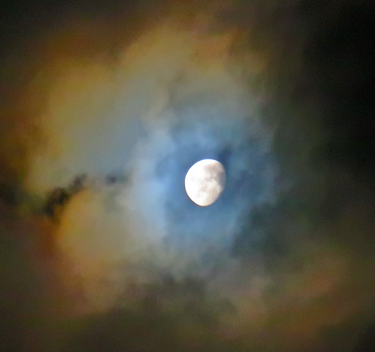 clouds around bright moon colored with orange and blue.JPG