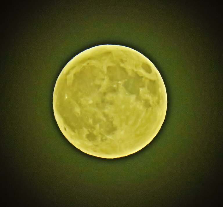 close up full moon circled in blue with rings of orange and yellow.JPG