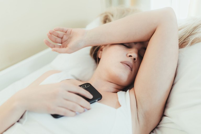 woman-lays-in-bed-with-hand-over-her-eyes.jpg