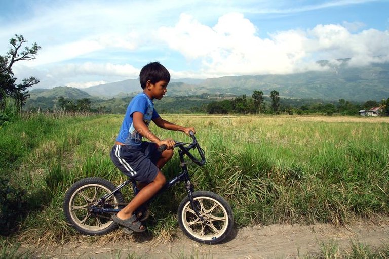 boy-rides-bicycle-along-rice-field-nueva-vizcaya-philippines-october-province-nueva-vizcaya-philippines-61792570.jpg